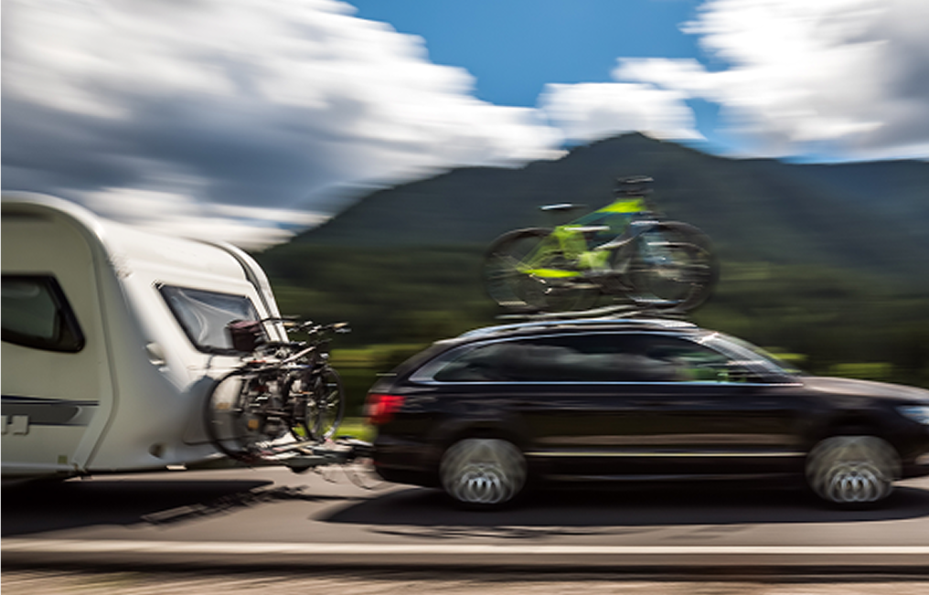 Car towing camper with bicycle rack